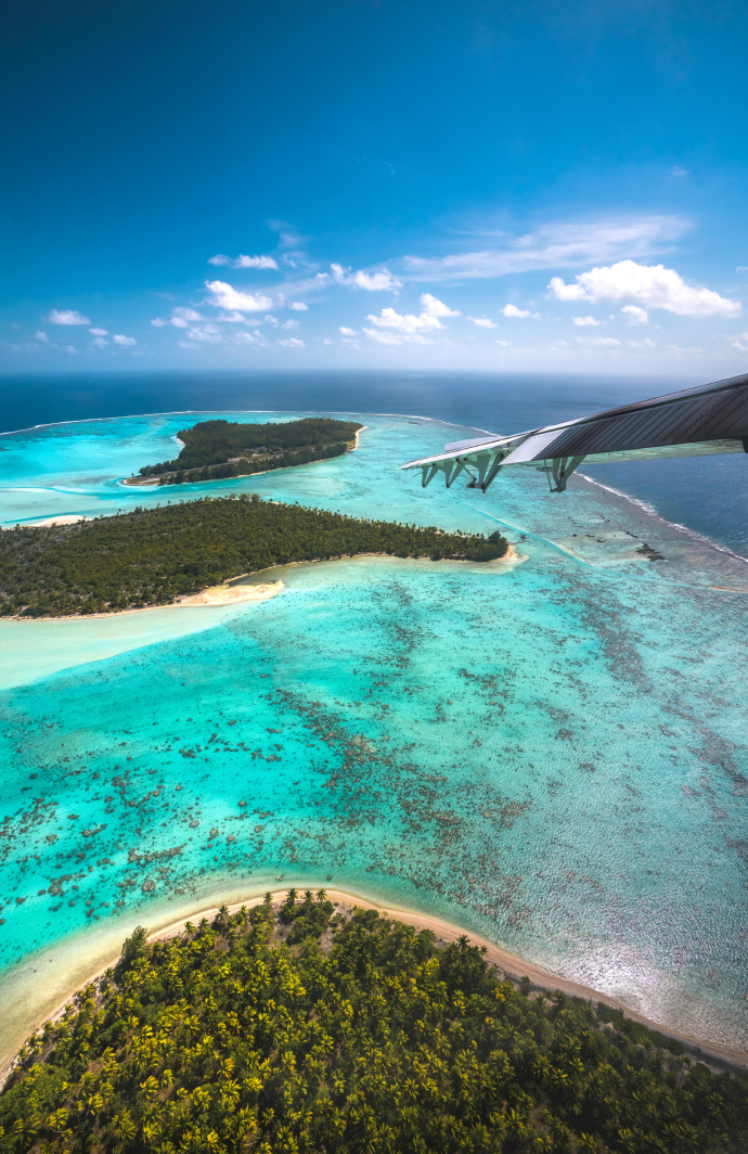 Bright blue water surrounding the Tetiaroa atoll, viewed from a plane