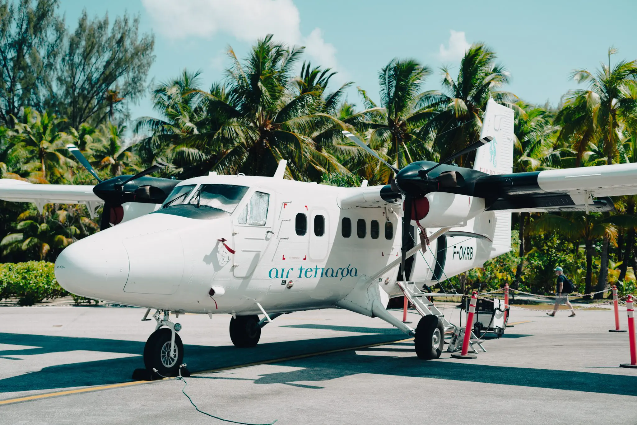 Small Air Tetiaroa plane on a concrete runway surrounded by palm trees