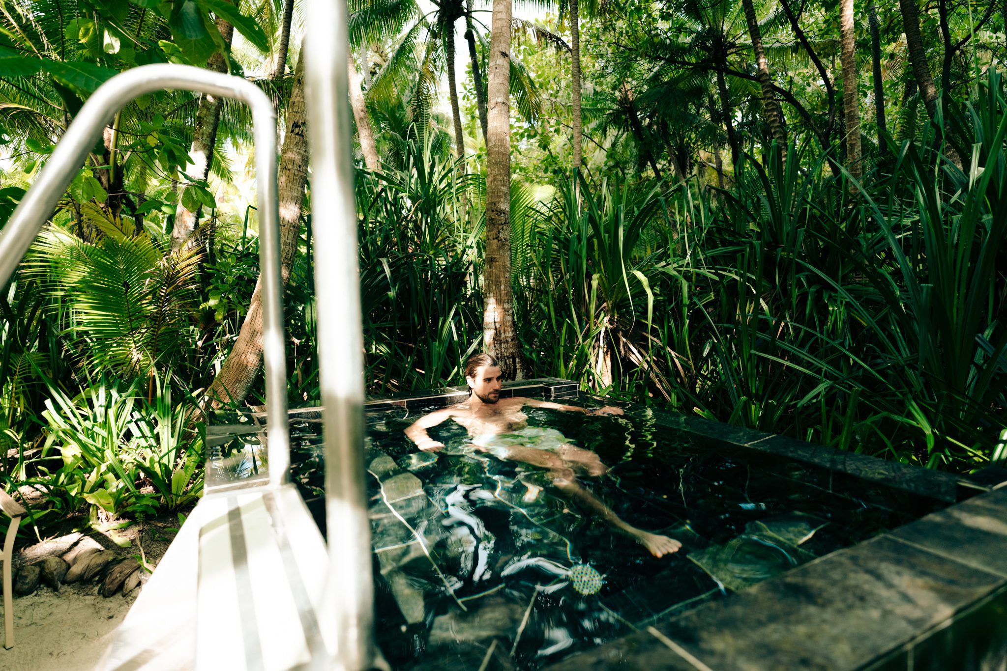 Man in an outdoor cold plunge pool at our all inclusive resort in Tahiti
