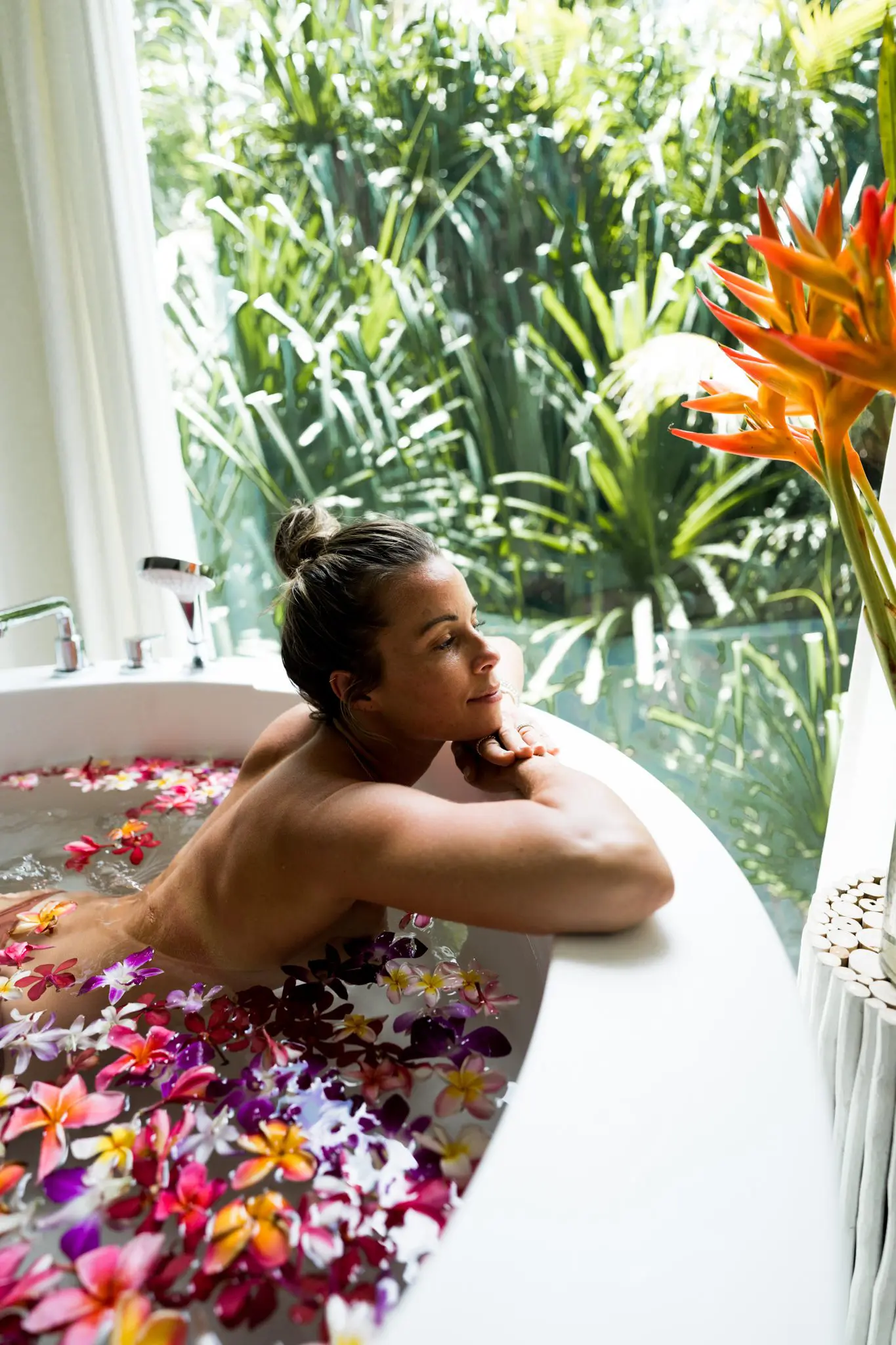 Nude woman in a bath with flower petals at our South Pacific resort