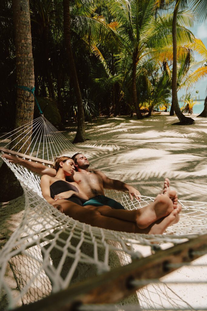 Couple in a hammock on a sandy beach at our private island resort