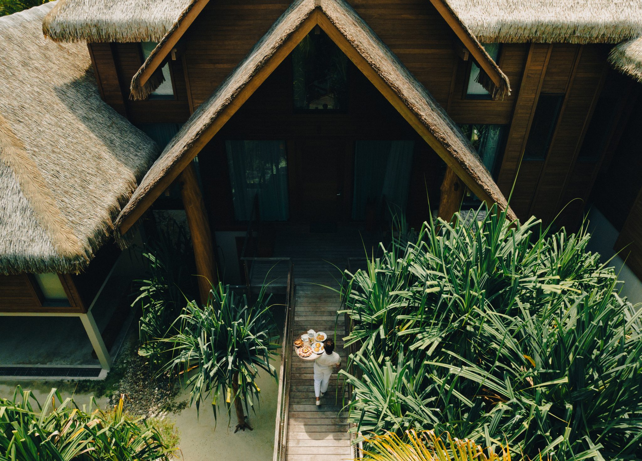 Aerial view of a man bringing food to a private French Polynesian villa