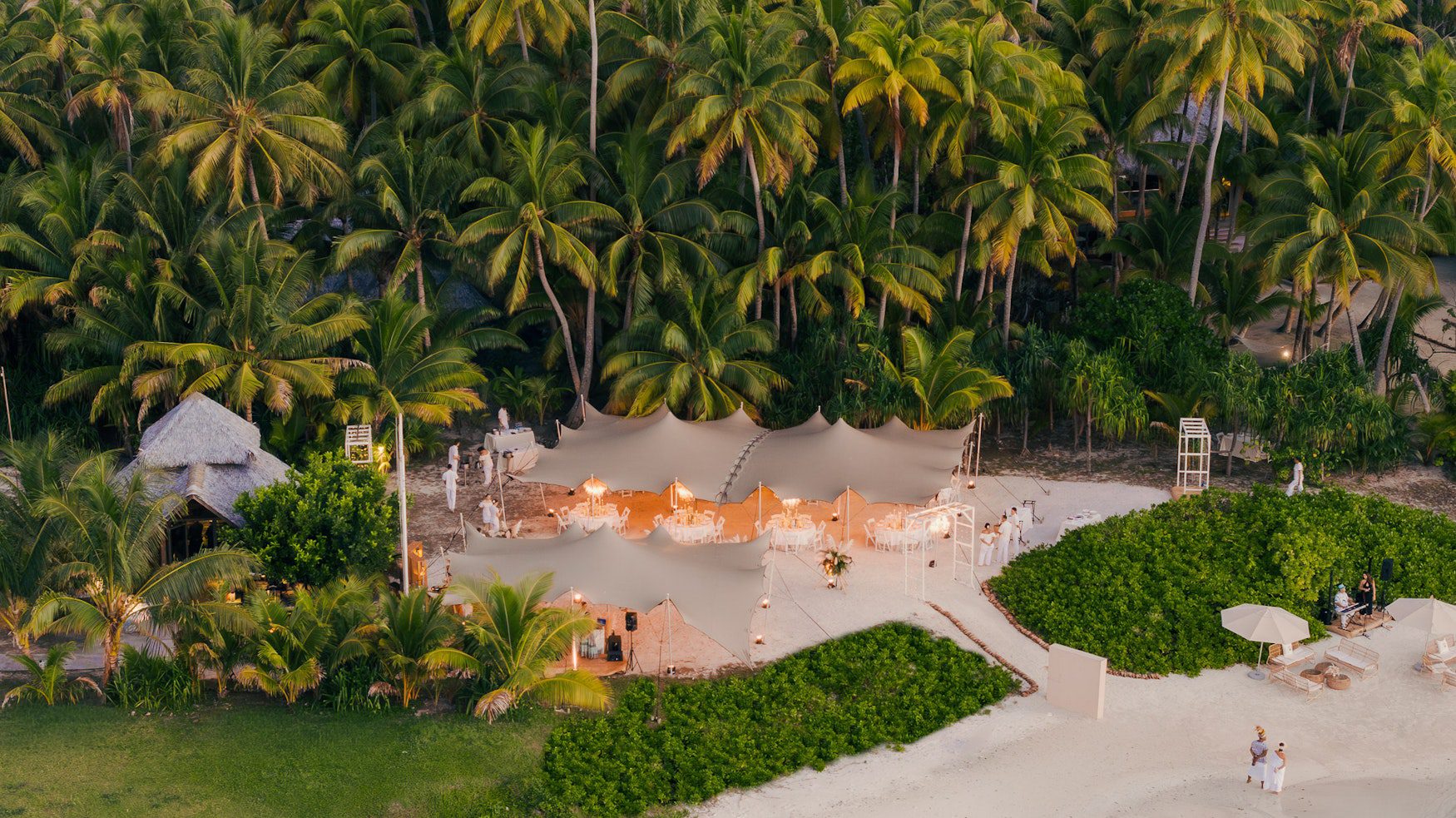 Aerial view of a luxury corporate incentive event with elegant stretch tents on the beach at The Brando, Tetiaroa, highlighting private island buyout and bespoke group celebrations.